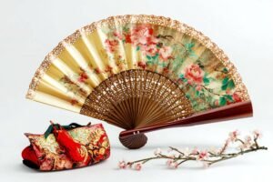 Éventail artisanal décoratif avec motif floral et bourse assortie.